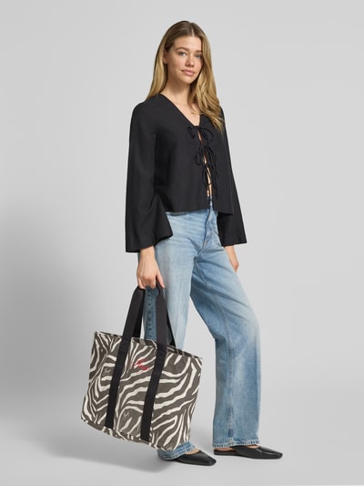 Frauenmodel trägt Shopper aus reiner Baumwolle Modell 'BECKY ZE_TOTE' von HUGO mit Animal Print, Label Print und Tragehenkeln, Ganzkörperansicht von vorne.