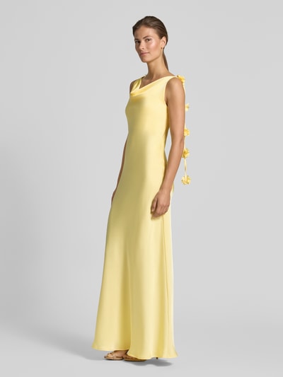 Frauenmodel trägt fließendes Maxikleid mit Blumenapplikationen Modell 'ANALEI' von Vero Moda in Optik: Unifarben, Satin, Maxi-Länge, Wasserfall-Ausschnitt, verstellbare Spaghettiträger, Ganzkörperansicht von vorne.