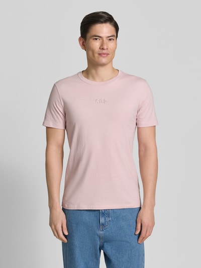 Männermodel trägt T-Shirt mit Rundhalsausschnitt und Label-Stitching von GAP, Reine Baumwolle, Regular-Fit, Hellrosa, Ganzkörperansicht von vorne. Rückenlänge bei Größe M: 69 cm.