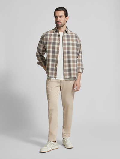 Männermodel trägt Chino mit Eingrifftaschen Modell 'Tino' von BRAX, Beige, Regular-Fit, Baumwoll-Elasthan-Mix, Ganzkörperansicht von vorne.