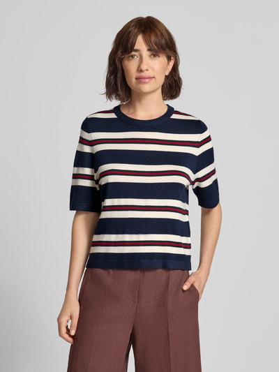 Frauenmodel trägt Boxy Fit Strickshirt aus Viskose-Mix Modell 'VMSILJE' von VERO MODA, Streifenmuster in Dunkelblau, Weiß und Bordeaux, Ganzkörperansicht von vorne. Damen Strickshirt von VERO MODA.
