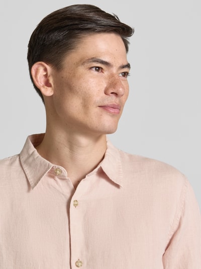 Männermodel trägt Regular Fit Leinenhemd mit Kentkragen von GAP in zartem Rosa, sichtbare Knopfleiste, Nahaufnahme Oberkörper. Reines Leinen, Rückenlänge 71 cm, Schulterbreite 49 cm, Ärmellänge 64 cm, Größe M.