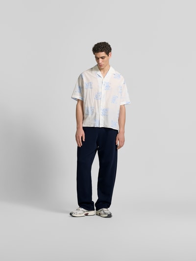 Männermodel trägt Wide Fit Sweatpants mit Eingrifftaschen von Kenzo aus reiner Baumwolle in Dunkelblau, Ganzkörperansicht von vorne.