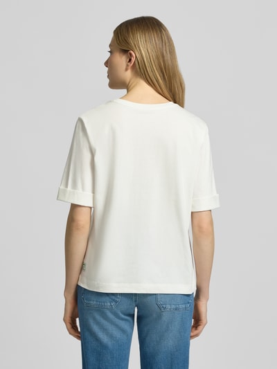 Frauenmodel trägt Slim Fit T-Shirt mit Motiv-Print von Marc Cain aus Reine Baumwolle, Halbarm, Rundhalsausschnitt, Rückenlänge 58 cm, Ganzkörperansicht Rückansicht.