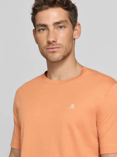 Männermodel trägt Regular Fit T-Shirt aus reiner Baumwolle von Marc O'Polo in Unifarbe mit Logo-Print, Nahaufnahme Oberkörper.