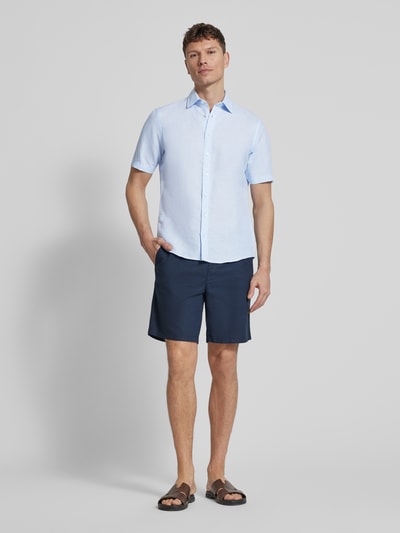 Männermodel trägt Slim Fit Freizeithemd aus Leinen-Mix von Jake*s, hellblau, Kentkragen, kurzärmelig, leichte Struktur, Ganzkörperansicht von vorne.