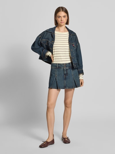 Frauenmodel trägt Regular Fit Langarmshirt aus reiner Baumwolle von Marc O'Polo DENIM, creme mit Streifen, glatte Textur, Ganzkörperansicht von vorne.