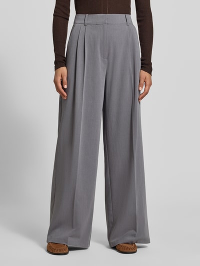 Frauenmodel trägt Wide Fit Hose mit Viskose-Anteil von MYON in Grau, elastischer Material-Mix, Bundfalten, Nahaufnahme Oberkörper.