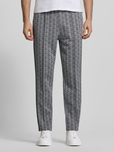 Männermodel trägt Regular Fit Sweathose mit Baumwoll-Anteil von Lacoste, Optik:Allover-Muster, Label Patch, Kontraststreifen, Sweat, Ganzkörperansicht von vorne.