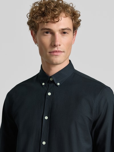 Männermodel trägt Regular Fit Freizeithemd aus Baumwoll-Mix Modell 'Oxford' von Lindbergh in Dunkelblau, Nahaufnahme Oberkörper. Baumwoll-Elasthan-Mix, Button-Down-Kragen, 1-Knopf-Manschetten, abgerundeter Saum.