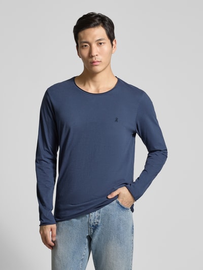 Männermodel trägt Regular Fit Langarmshirt aus reiner Baumwolle Modell 'JAAMES' von Armedangels in Dunkelblau, Jerseytextur, Ganzkörperansicht von vorne.