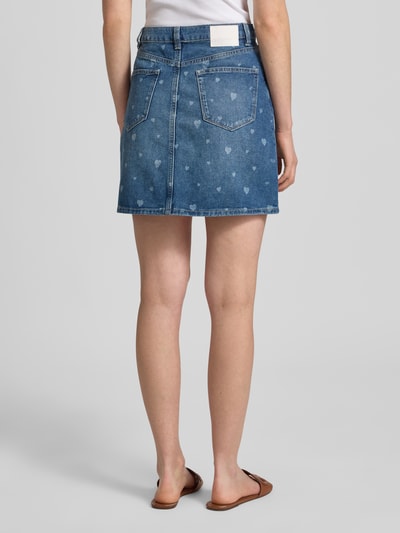 Frauenmodel trägt Mini-Jeansrock aus reiner Baumwolle von Tom Tailor Denim mit Optik:Allover-Muster, Herzmuster, 5-Pocket-Design, Denim, Nieten, Label-Patch, Mini-Länge, Farbe Blau, Materialverarbeitung: reine Baumwolle, Ganzkörperansicht Rückansicht.