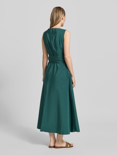 Frauenmodel trägt A-Linie Abendkleid mit Baumwoll-Anteil Modell 'GENTILE' von Weekend Max Mara in Dunkelgrün, glatte Textur, Ganzkörperansicht Rückansicht. Damen Abendkleid von Max Mara.