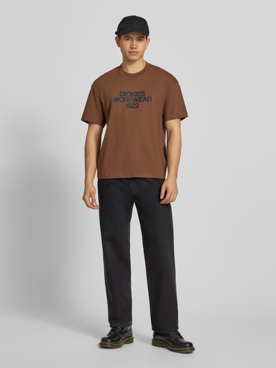 Männermodel trägt T-shirt mit labelprint Modell 'TORREY' von Dickies, puur katoen, regular fit, ronde hals, ruglengte maat M 70 cm, ganzlichaamsvooraanzicht.