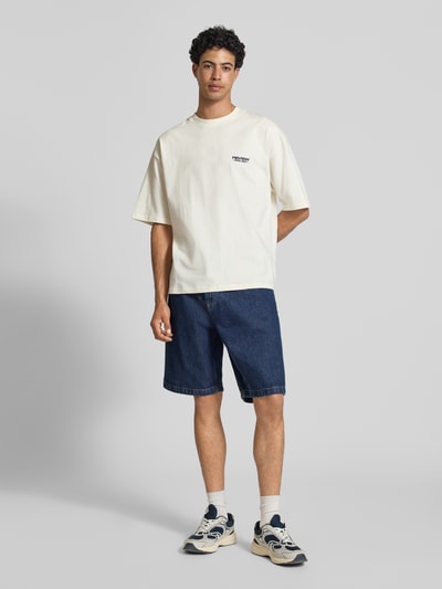 Männermodel trägt T-Shirt mit Rundhalsausschnitt und Logo-Print von REVIEW, Herren T-Shirt aus Reine Baumwolle, Modern Fit, Ganzkörperansicht von vorne
