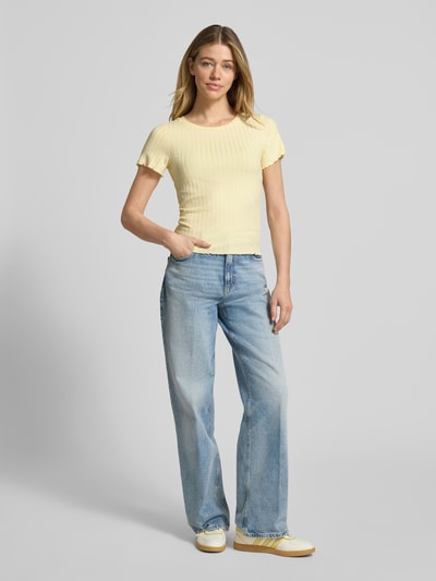 Frauenmodel trägt T-Shirt aus Viskose-Mix mit Rundhalsausschnitt von Rich & Royal, Strukturmuster, Straight Fit, Stretch-Anteil, gelb, Rückenlänge bei Größe S 51 cm, Ganzkörperansicht von vorne.