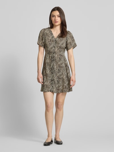 Frauenmodel trägt Minikleid aus reiner Viskose Modell 'EVIDA' von Only mit Allover-Muster, V-Ausschnitt, Taillengürtel, taillierte Passform, Ganzkörperansicht von vorne.