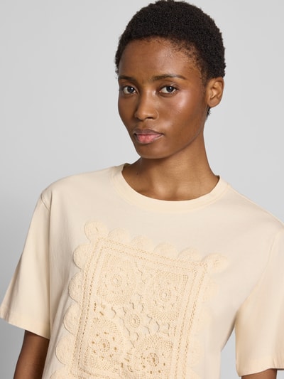 Kobieta modelka nosi damski t-shirt z bawełny Regular Fit model 'T066-BFCrochet' od Jake*s Casual w kremowym kolorze, detal z przodu, zbliżenie na górną część ciała.