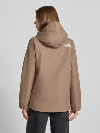 Frauenmodel trägt Regular Fit Funktionsjacke mit Logo-Print Modell 'Quest Mono' von The North Face in Beige, Rückenansicht, Damen Funktionsjacke mit Kapuze und Reißverschluss, KI-modifiziertes Bild.