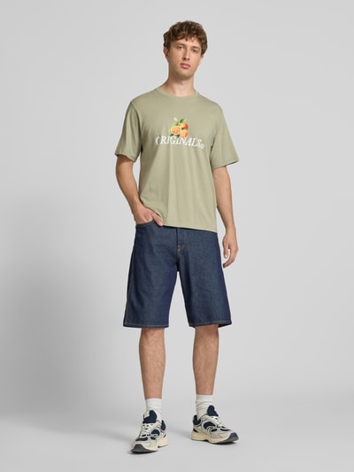 Mężczyzna nosi Regular Fit T-Shirt mit Statement-Print Modell 'Eres' von Jack & Jones, bawełna, okrągły dekolt, kolor oliwkowy, Ganzkörperansicht von vorne.