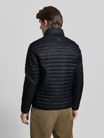 Männermodel trägt schwarze Steppjacke mit Stehkragen von camel active, Regular Fit, Rückansicht, Ganzkörperansicht von hinten.
