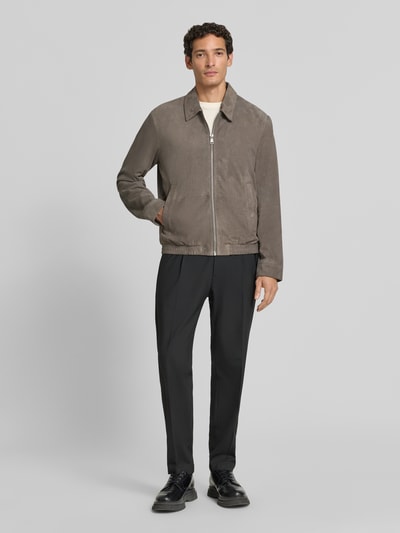 Männermodel trägt Regular Fit Lederjacke aus echtem Ziegenleder von Marc O'Polo in Braun, kombiniert mit schwarzer Hose, Ganzkörperansicht von vorne. Herren Leder- / Kunstlederjacke von Marc O'Polo.