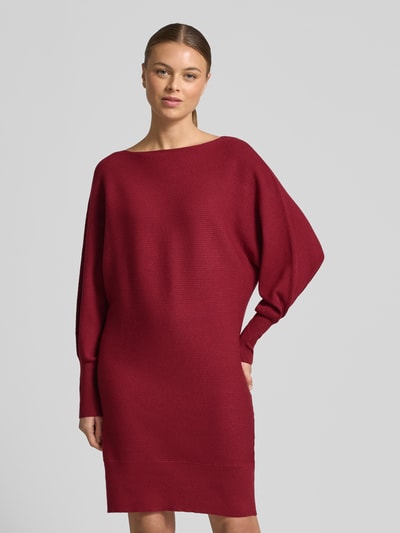 Frauenmodel trägt Relaxed Fit Sukienka aus mieszanka wiskozy w imitacji dzianiny od Zero, długość do kolan, długi rękaw, okrągły dekolt, elastyczne i szerokie zakończenia rękawów, kolor bordowy, gładka tekstura, widoczna struktura dzianiny, sukienka casualowa, Ganzkörperansicht von vorne.
