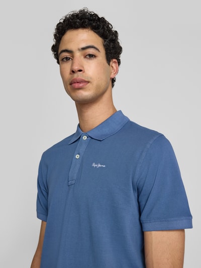 Männermodel trägt Regular Fit Poloshirt aus reiner Baumwolle Modell 'OSCAR' von Pepe Jeans, Optik: Unifarben, Nahaufnahme Oberkörper.