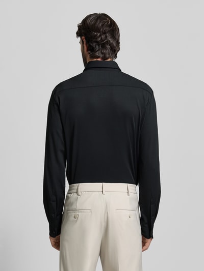 Männermodel trägt Slim Fit Business Hemd mit Kentkragen Modell 'ROAN' von BOSS, unifarben, einreihige Knopfleiste, Ganzkörperansicht Rückansicht.