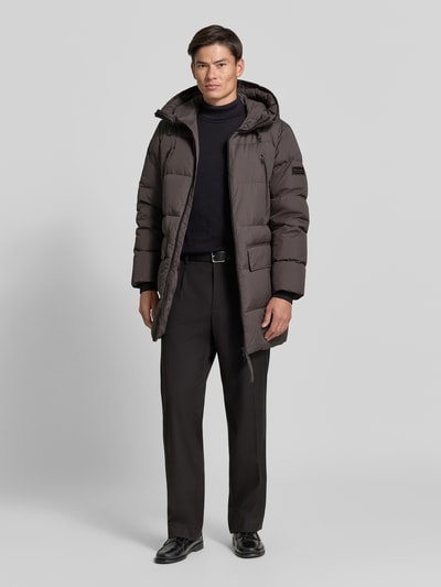 Männermodel trägt Regular Fit Daunenjacke mit Kapuze von Marc O'Polo in Unifarbe, wasserabweisend, Ganzkörperansicht von vorne.