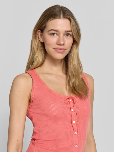 Modelka nosi Trägertop mit Rundhalsausschnitt und Knopfleiste von Jake*s Casual z bawełny, krój slim fit, okrągły dekolt, listwa guzikowa, długość tyłu w rozmiarze S: 52 cm, kolor różowy, tekstura prążkowana, zbliżenie na górną część ciała z przodu.