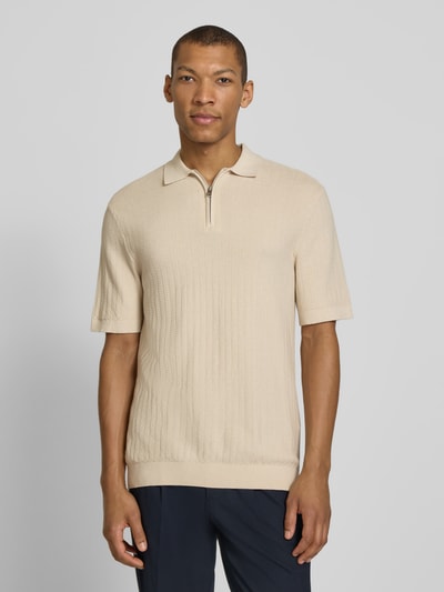 Męski model nosi Regular Fit Poloshirt aus reiner Baumwolle Modell 'CRAN' od SELECTED HOMME, beżowy, dzianinowa struktura, krótki rękaw, kołnierzyk polo, krótki zamek, widok na cały przód sylwetki.