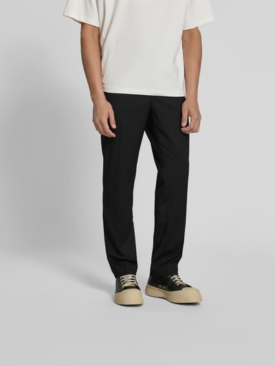 Männermodel trägt Slim Fit Anzughose mit Woll-Anteil von Filippa K im Elastischer-Material-Mix, Schwarz, Bundfalten, Ganzkörperansicht von vorne.