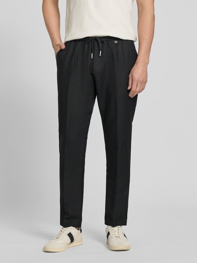 Männermodel trägt Regular Fit Hose aus Leinen-Viskose-Mix Modell 'NEIL' von Antony Morato in Schwarz mit Bügelfalten, elastischer Bund, glatte Oberfläche, Bundweite bei Größe 50: 44 cm, Innenbeinlänge bei Größe 50: 74 cm, Ganzkörperansicht von vorne.