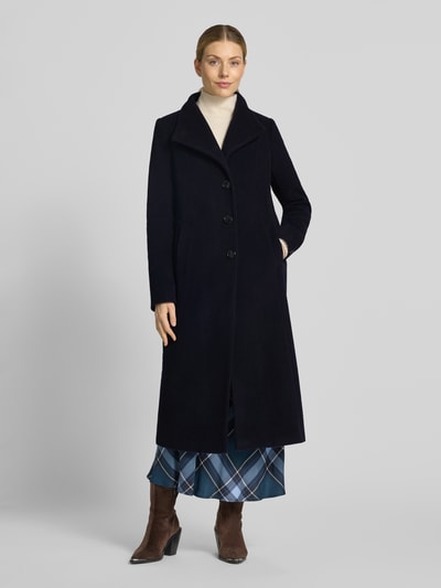 Vrouwenmodel draagt Regular fit lange jas met opstaande kraag Model 'NADA' van Milo Coats, Materiaalmix met scheerwol, knoopsluiting, steekzakken, ruglengte maat 36: 118 cm, schouderbreedte: 40 cm, borstwijdte: 47 cm, mouwlengte: 67 cm, donkerblauw, rechte vorm, zachte textuur, volledig lichaam van voren.