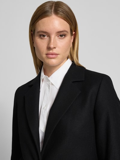 Frauenmodel trägt schwarzen Relaxed Fit Mantel aus Woll-Mix Modell 'Mojeni' von HUGO, Damen Mantel, Nahaufnahme Oberkörper.