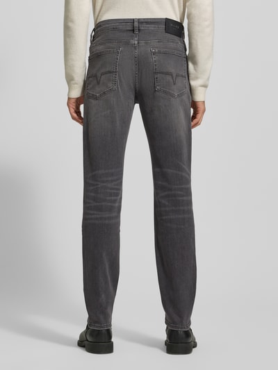 Männermodel trägt Regular Fit Jeans mit Stretch-Anteil Modell 'Mitch' von JOOP! Jeans, grauer Baumwoll-Mix, 5-Pocket-Design, Label-Patch aus echtem Leder, elastischer Bund, Knopf- und Reißverschluss, Ganzkörperansicht Rückansicht.