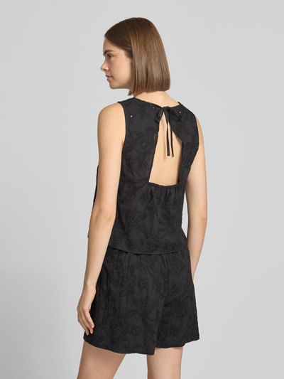 Frauenmodel trägt schwarzes Regular Fit Blusentop aus reiner Baumwolle Modell 'PCGINGER' von PIECES mit floraler Struktur, Ganzkörperansicht Rückansicht.