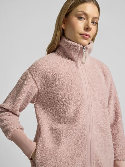 Frauenmodel trägt Fleecejacke mit Stehkragen Modell 'TOLA' von Didriksons in Rosa, Relaxed Fit, Nahaufnahme Oberkörper.