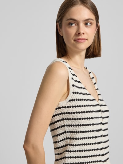 Frauenmodel trägt Strickweste mit V-Ausschnitt und Knopfleiste von REVIEW, gestreifter Allover-Look, Material-Mix mit Baumwoll-Anteil, Nahaufnahme Oberkörper