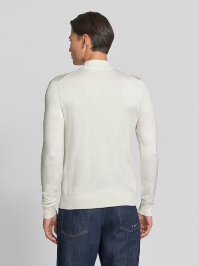Männermodel trägt Rollkragenpullover mit Viskose-Anteil von MARKUP in Creme, gerader Schnitt, gerippte Abschlüsse, Ganzkörperansicht Rückansicht.