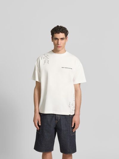 Männermodel trägt Relaxed Fit T-Shirt aus Baumwoll-Mix von Don’t Waste Culture mit Rundhalsausschnitt, Motiv-Print, Label-Print, Vorderansicht Ganzkörperansicht.