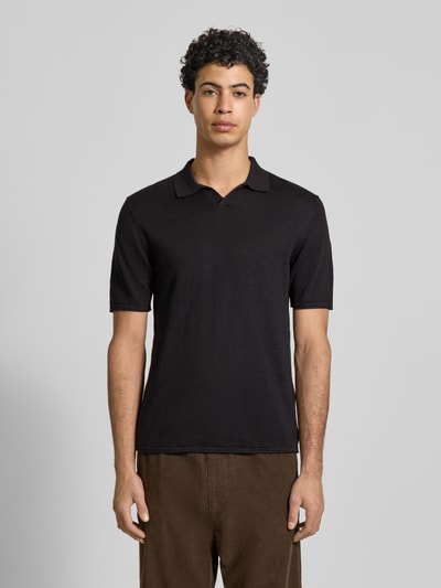 Männermodel trägt Slim Fit Poloshirt in Strick-Optik Modell 'Kane' von JACK & JONES aus reiner Baumwolle, kurzärmelig, Ganzkörperansicht von vorne.