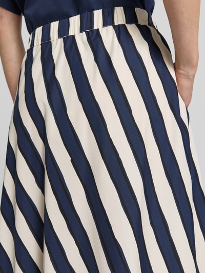 Frauenmodel trägt Ausgestellter Maxi-Rock aus reiner Baumwolle von Weekend Max Mara mit blau-weißem Allover-Muster, elastischer Bund, seitliche Eingrifftaschen, Nahaufnahme Oberkörper.