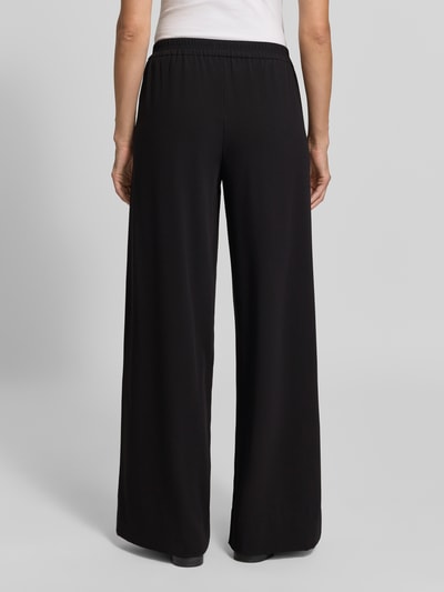 Frauenmodel trägt schwarze Weite Hose mit elastischem Bund Modell 'Coralie' von MAC, glatte Textur, Ganzkörperansicht Rückansicht, Damen Weite Hose von MAC.