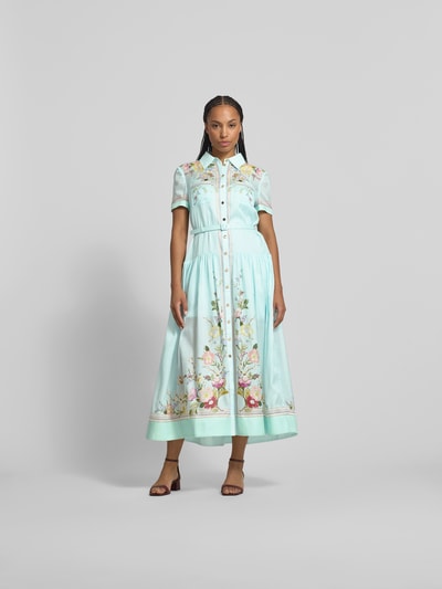 Frauenmodel trägt Midikleid mit Seide-Anteil von Self-Portrait im hellen Baumwoll-Mix, taillierte Passform, Brusttaschen, Gürtel, kurzärmelig, florale Muster, Gesamtlänge 134 cm, Brustweite 46 cm, Ärmellänge 20 cm, Ganzkörperansicht von vorne.