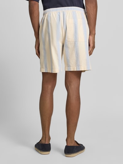 Männermodel trägt Regular Fit Shorts aus reiner Baumwolle von Armedangels mit Optik:Allover-Muster, Gestreift, Twill, Ganzkörperansicht Rückansicht.