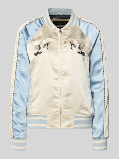 Produktfoto, Bomber Jacke mit Motiv- und Logo-Stitching von Superdry, satynowa, kremowe i jasnoniebieskie panele, prosty krój, krótki stójka, zamek, boczne kieszenie, elastyczne wykończenia, długość pleców w rozmiarze S: 58 cm, szerokość ramion w rozmiarze S: 45 cm, szerokość klatki piersiowej w rozmiarze S: 53 cm, długość rękawa w rozmiarze S: 64 cm