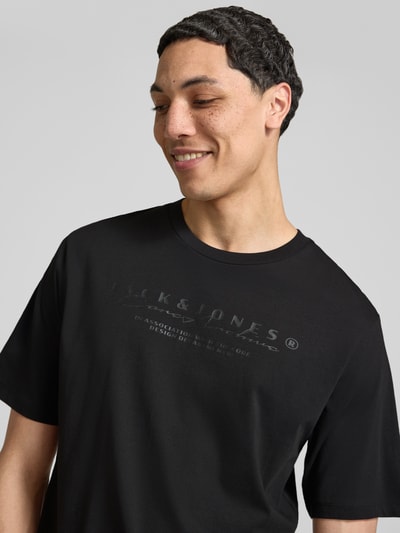Męski model nosi T-Shirt z logo i okrągłym dekoltem od Jack & Jones, czysta bawełna, krój regular fit, ujęcie z przodu zbliżenie