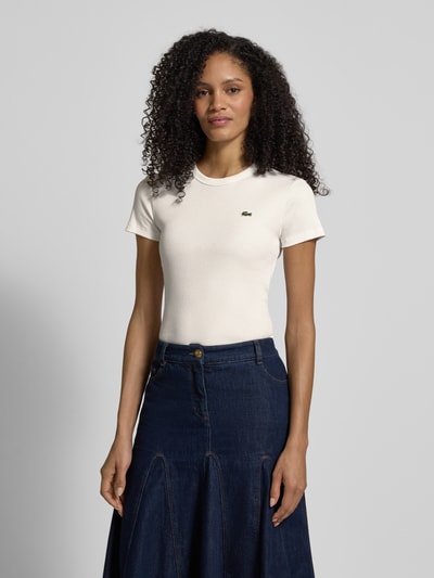 Frauenmodel trägt Slim Fit T-Shirt aus reiner Baumwolle von Lacoste Sport in Unifarben mit Logo-Stitching, Rundhals, kurzarm, Rippstruktur, Ganzkörperansicht von vorne.